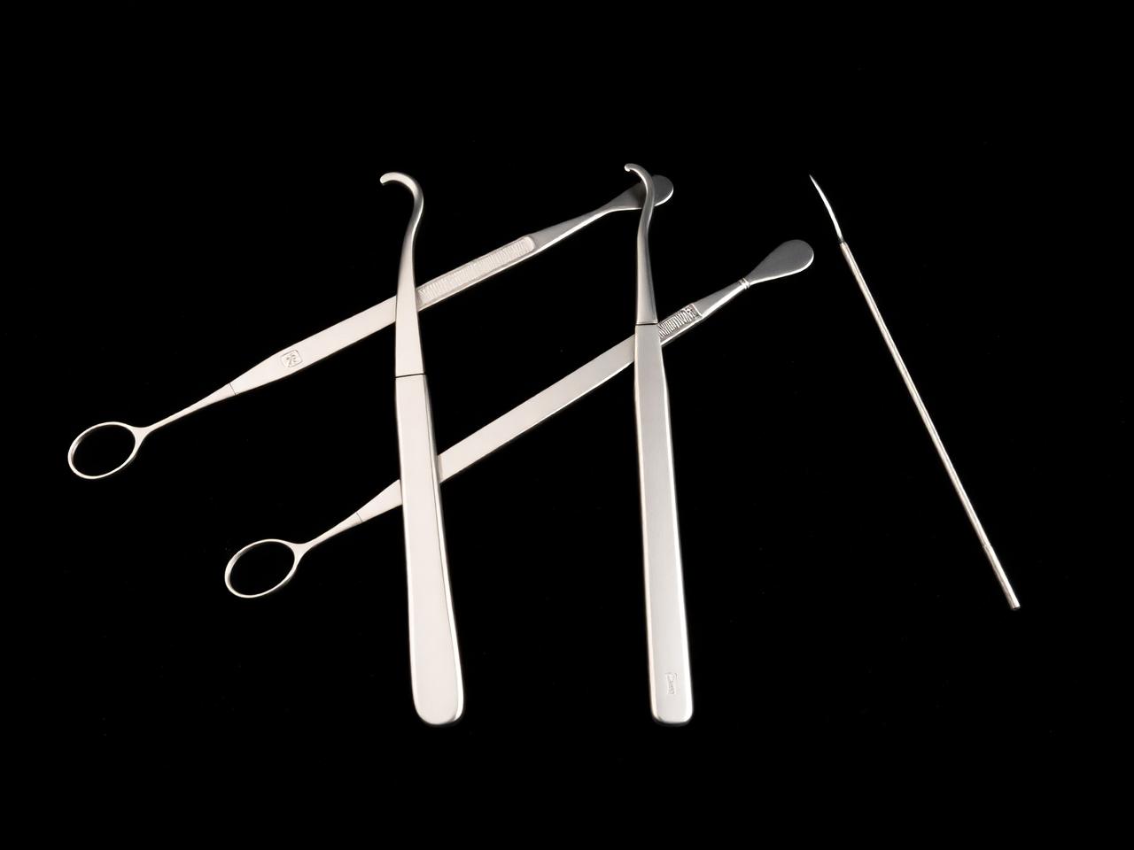 Precision dental hand-instruments arranged on dark velvet